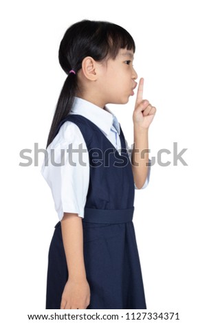 Asian Little Chinese Girl putting finger up to lips and asking for silence in isolated White Background