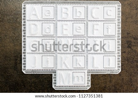Alphabet printed in 3d on white square tiles. Set of uppercase and lowercase letters to make typographic tones made with a 3D printer. Maker activity fo children education. Letters from A to M 