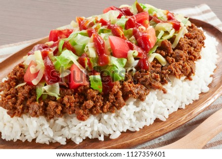 Rice Topped with a Taco Filling Royalty-Free Stock Photo #1127359601