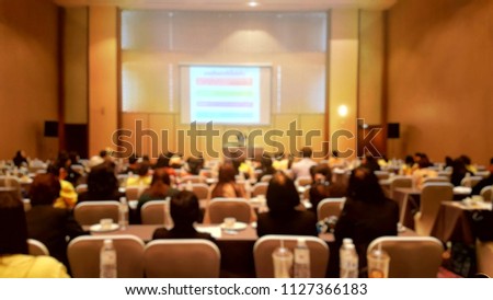 Blurred photo of seminar hall. The audience listen to speech about business.