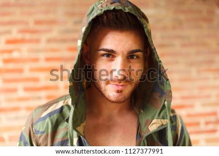 Fashion guy with green jacket looking at camera