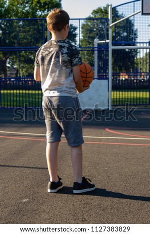 Pre-teen boy playing with a basketball in a park