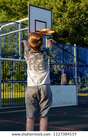 Pre-teen boy playing with a basketball in a park