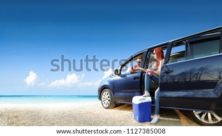 Summer trip on beach. Blue car with two people and sea landscape. Free space for your text. 