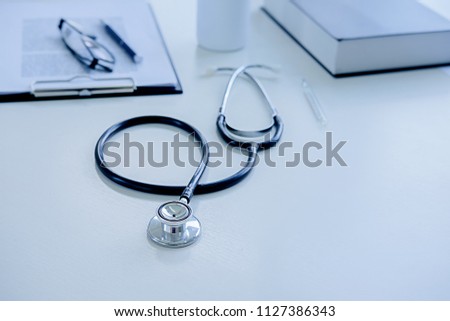 Stethoscope with clipboard and Laptop on desk, Doctor working in hospital writing a prescription, Healthcare and medical concept, test results in background,