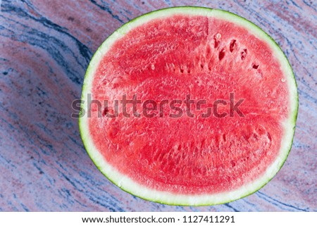 half watermelon on pink marble background with dark blue strokes