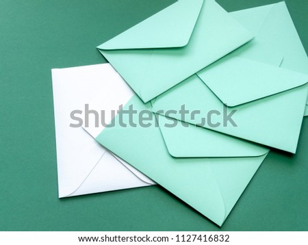 Composition with green envelopes and one white envelope on green background