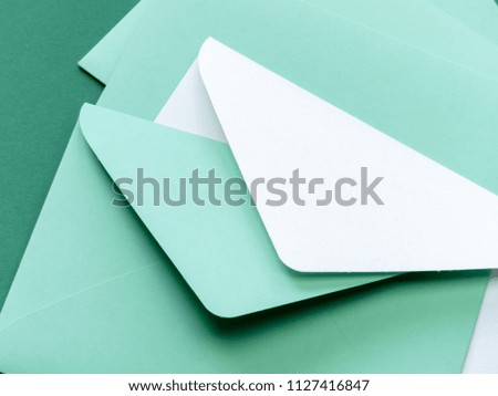 Composition with green envelopes and one white envelope on green background