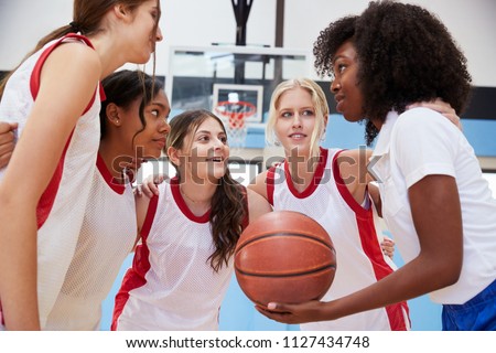 Female High School Basketball Players In Huddle Having Team Talk With Coach