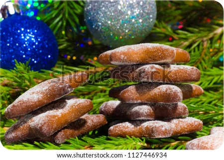 New Year post card: shortbread cookies and Christmas balls on a background of fir branches