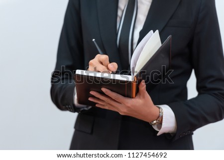 Key to success, woman hand taking notes at a business meeting for personal reference, while meeting minutes are for official record-keeping purposes. Royalty-Free Stock Photo #1127454692