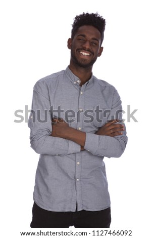 Handsome young African man in casual wear keeping arms crossed and smiling, isolated on a white background. Royalty-Free Stock Photo #1127466092