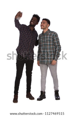 A full-length photo of two Happy friends taking selfie, isolated on a white background.