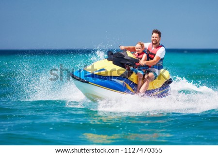 happy, excited family, father and son having fun on jet ski at summer vacation Royalty-Free Stock Photo #1127470355