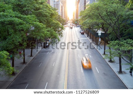 New York City taxi speeding down 42nd Street in Midtown Manhattan with the sunset in the background Royalty-Free Stock Photo #1127526809