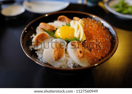 Scallop urchin Ikura (salmon eggs) don. Donburi is a Japanese rice bowl dish consisting of fish, meat, vegetables or other ingredients simmered together and served over rice.