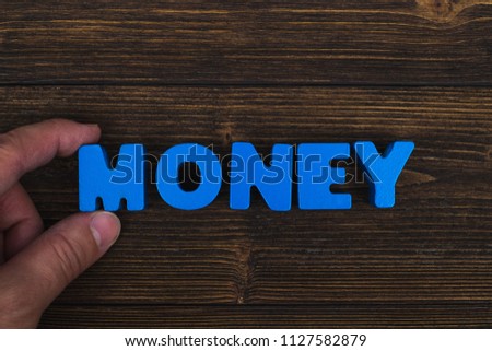 Hand and finger arrange text letters of MONEY word on wood table, with copy space for add advertising word or product. business and finance concept idea.