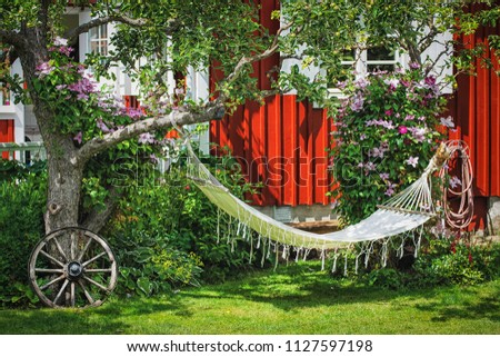Picture of backyard area with hammock and old vintage details on the green grass.