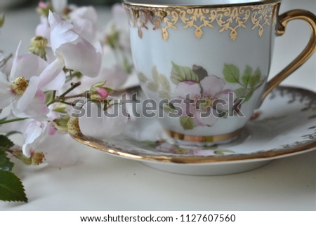  Pink roses and coffee cup on wooden table.
