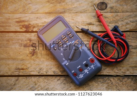 digital multimeter and wiring on wooden table. special tools of technician for work with circuit and electrical. technician use the digital multimeter in workshop for check and repair equipment.