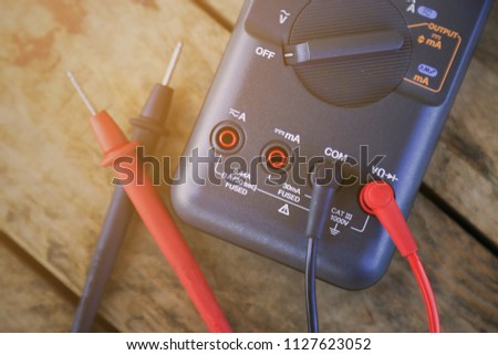 digital multimeter and wiring on wooden table. special tools of technician for work with circuit and electrical. technician use the digital multimeter in workshop for check and repair equipment.