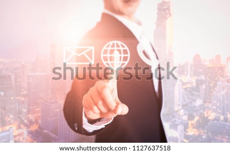 Businessman clicks on the earth letter and phone 