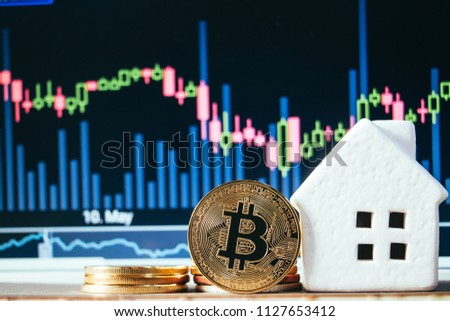Coins stack put on wood table and house model with bokeh natural background. Concept bitcoin for real estate investment.