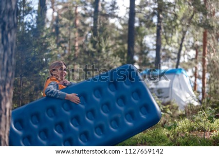A girl in the woods carries an air mattress Royalty-Free Stock Photo #1127659142