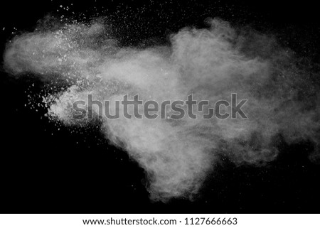 Bizarre forms of  white powder explosion cloud against dark background. Launched white dust particle splash on black background.