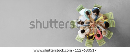 education, teamwork and people concept - group of international students with books and tablet pc computers putting hands on top of each other sitting at round table Royalty-Free Stock Photo #1127680517