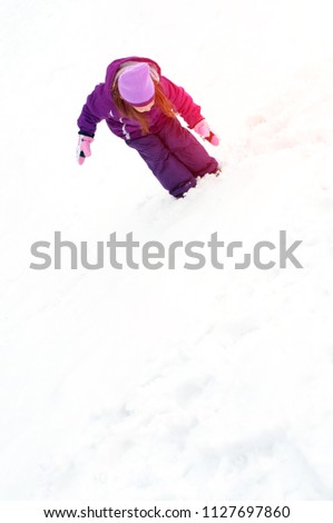 Cheerful little girl playing with snow