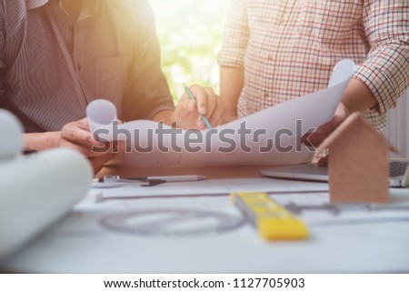 Architects engineer discussing on desk with blueprint. Team group on construciton site check documents and business workflow.house model for concept investment mortgage finance and home loan business