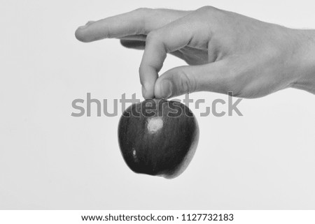 Food and healthy lifestyle concept. Male hand holds red apple. Apple isolated on light grey background. Apple fruit in fresh and juicy color.
