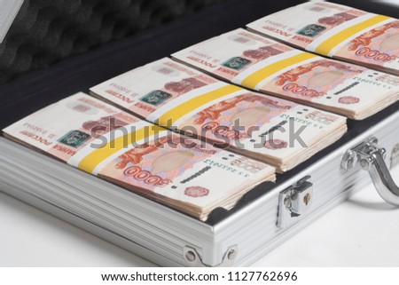 Suitcase full of rubles on white background Royalty-Free Stock Photo #1127762696