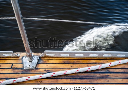 The deck of the yacht that moves fast, in the background is a blurred wave.