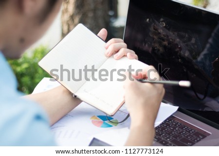 business documents on office table with smart phone and digital tablet and graph financial with social network diagram and man working in the background