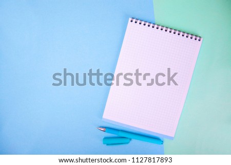 notebook, pen on blue background. top view copy space
