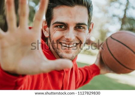 portrait of young man playing with basketball