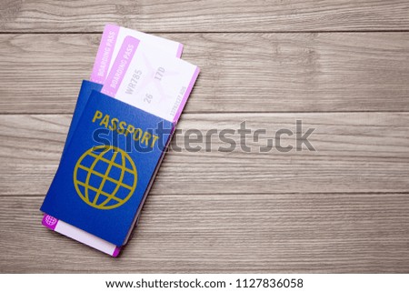 Two tickets for a plane with passports on an old wooden table. Copy space for text