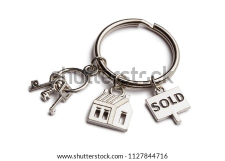 Keychain with mini keys, house and sign "sold", isolated on white background