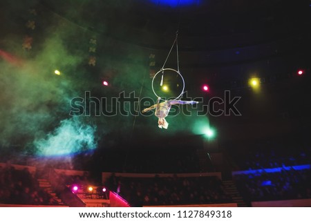 Aerial acrobat in the ring. A young girl performs the acrobatic elements in the air ring.