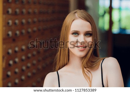 beautiful young girl with dark straight hair opens box and searches for data in the file cabinet in the library