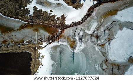Geode colors and a frozen Colorado mountain pond aerial view.