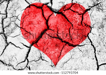 natural red heart shape in cracked dry soil Royalty-Free Stock Photo #112793704