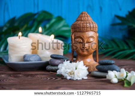 Pyramids of gray zen stones with statue of Buddha and fresh white flowers. Concept of harmony, balance and meditation, spa, massage, relax