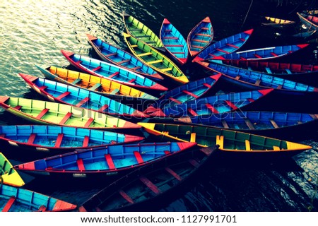 Colorful boats at the shore with sunset and reflective on the water.