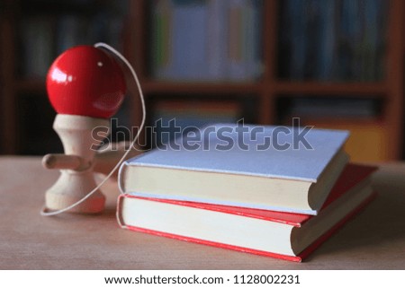 Close-up of book stacked on library table wooden toys on the side bookshelf is the background selective focus and shallow depth of field