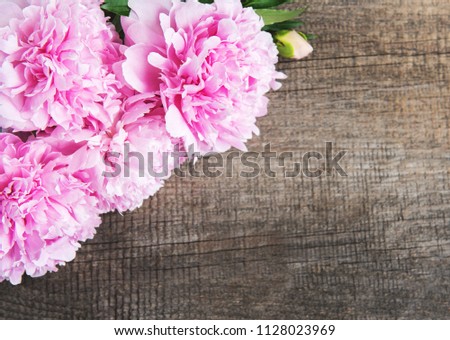 Pink peony flowers on a old  wooden table