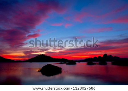 Beautiful colors sunset sky reflect Over on the lake, in Thailand.