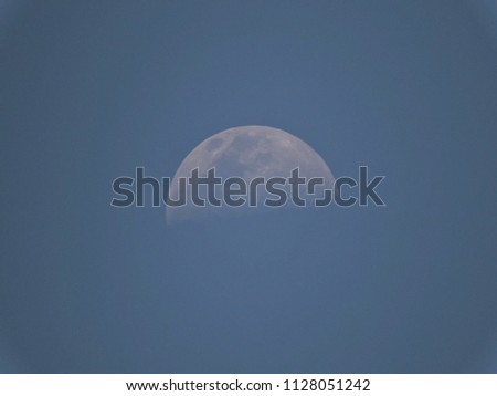 The moon in the clear sky, on a blue background